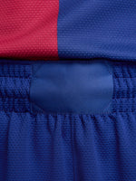 Man wearing blue FC Barcelona shorts featuring the club crest and Nike logo.