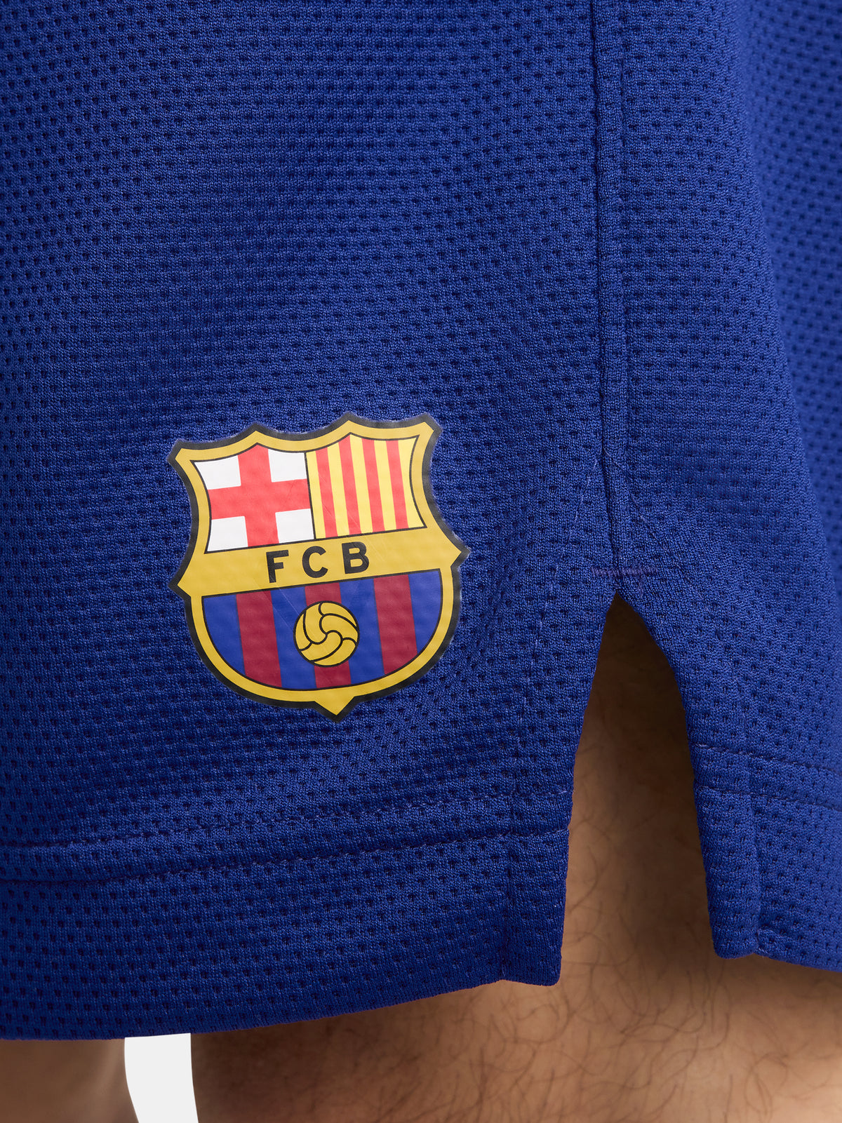 Man wearing blue FC Barcelona shorts featuring the club crest and Nike logo.