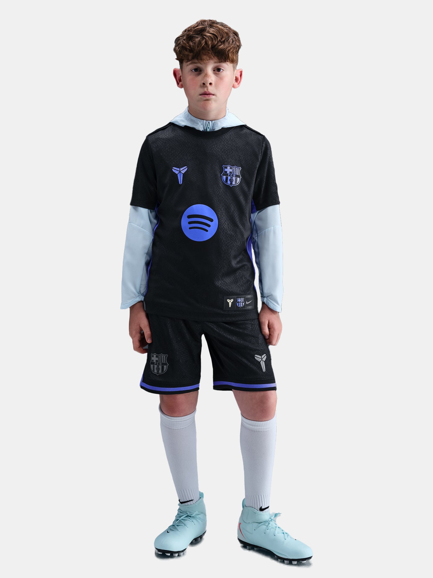 Child wearing a sports uniform with visible branding on a light gray background