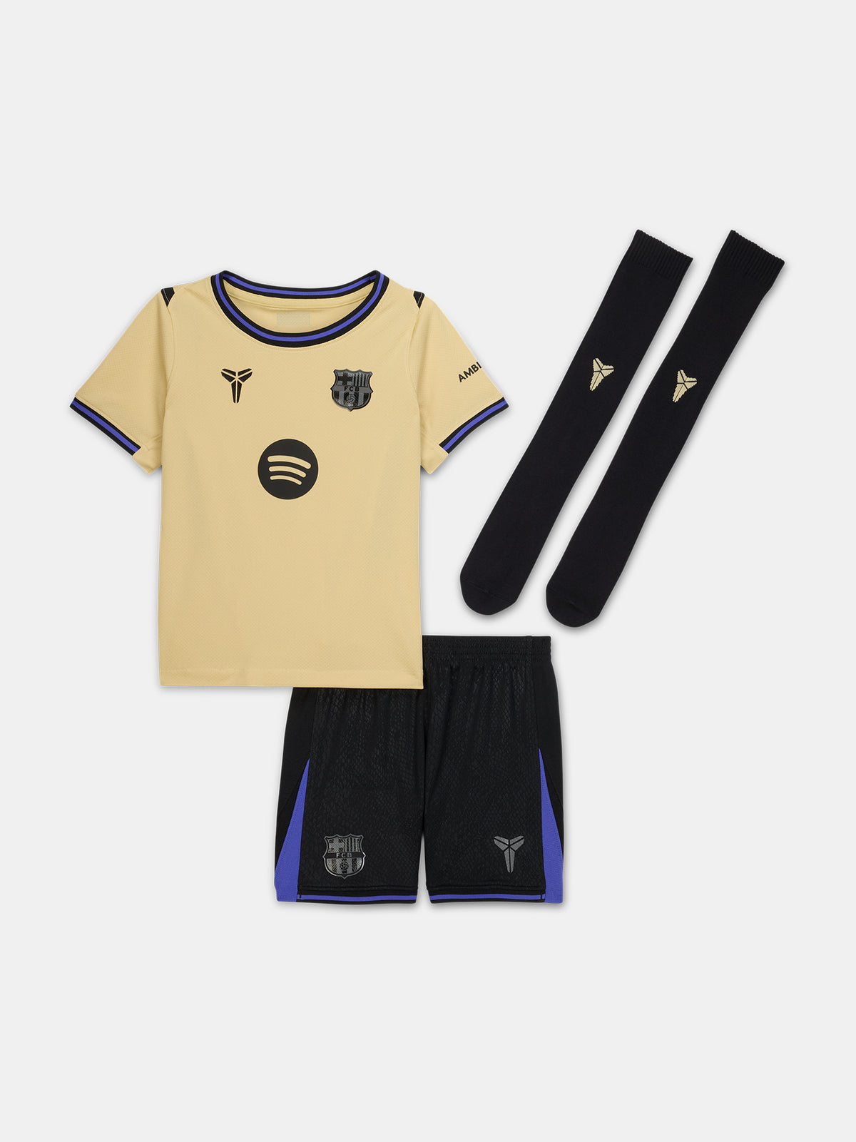 FC Barcelona kids' away kit set including beige jersey with black and purple details, black shorts with purple accents, and matching black socks, featuring club crest, Nike logo, Spotify sponsor, and Kobe Bryant tribute emblem.