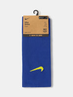 Blue Nike sock with yellow swoosh logo on a white background