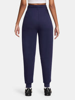 FC Barcelona women’s fleece joggers in navy blue. These pants feature a high-rise fit with an elastic drawstring waistband, ribbed cuffs, and front seams. The Barça crest and yellow Nike swoosh are placed on the front for a bold and sporty finish. Ideal for everyday comfort or casual training wear.
