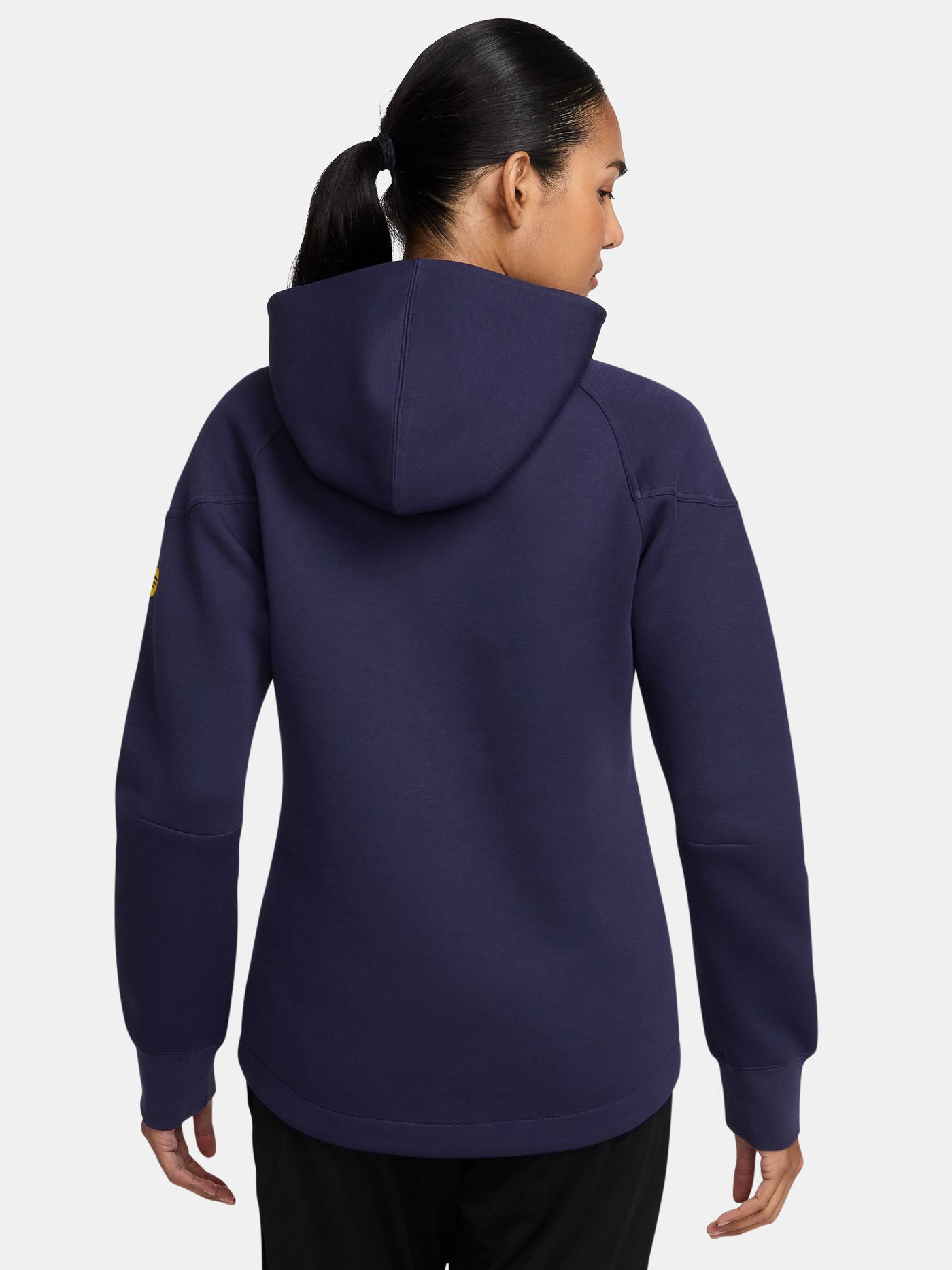 FC Barcelona women’s full-zip hoodie in navy blue. This jacket features a streamlined design with a high collar and front zip, complete with the club crest and yellow Nike swoosh. Designed for comfort and warmth with zippered side pockets and a modern, sporty silhouette.
