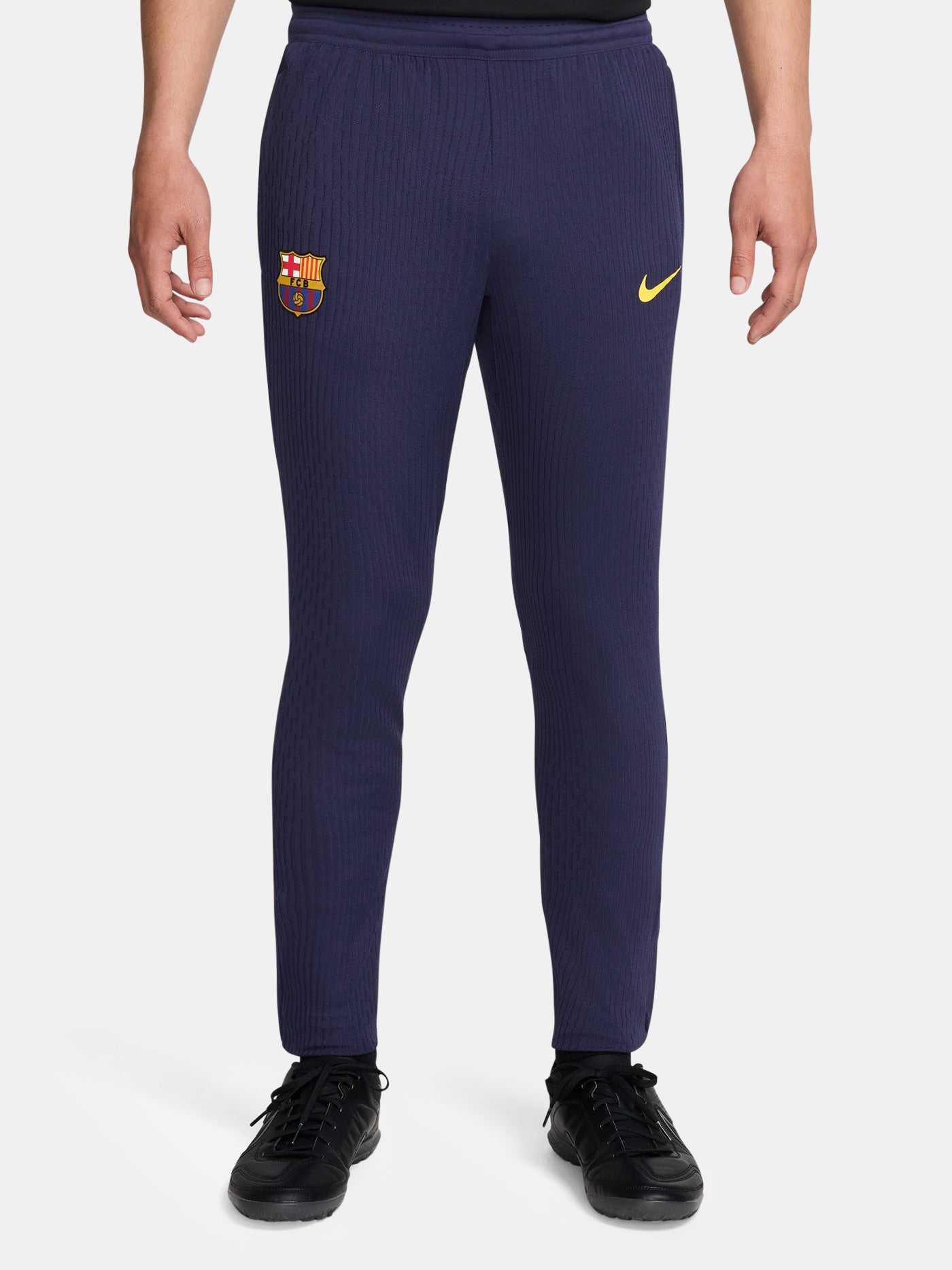FC Barcelona 2025/26 training pants in deep navy blue with a slim-fit cut. Featuring a textured fabric, elastic waistband, and zip cuffs for comfort and versatility. The iconic Barça crest and yellow Nike swoosh are embroidered on the front.
