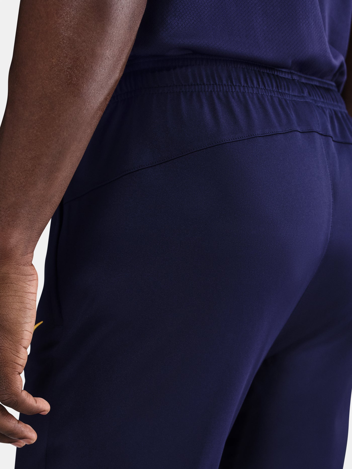 FC Barcelona tapered training pants in navy blue. Designed for performance and comfort with a slim fit, featuring the club crest and a yellow Nike swoosh on the front. Ideal for training sessions or casual wear.

