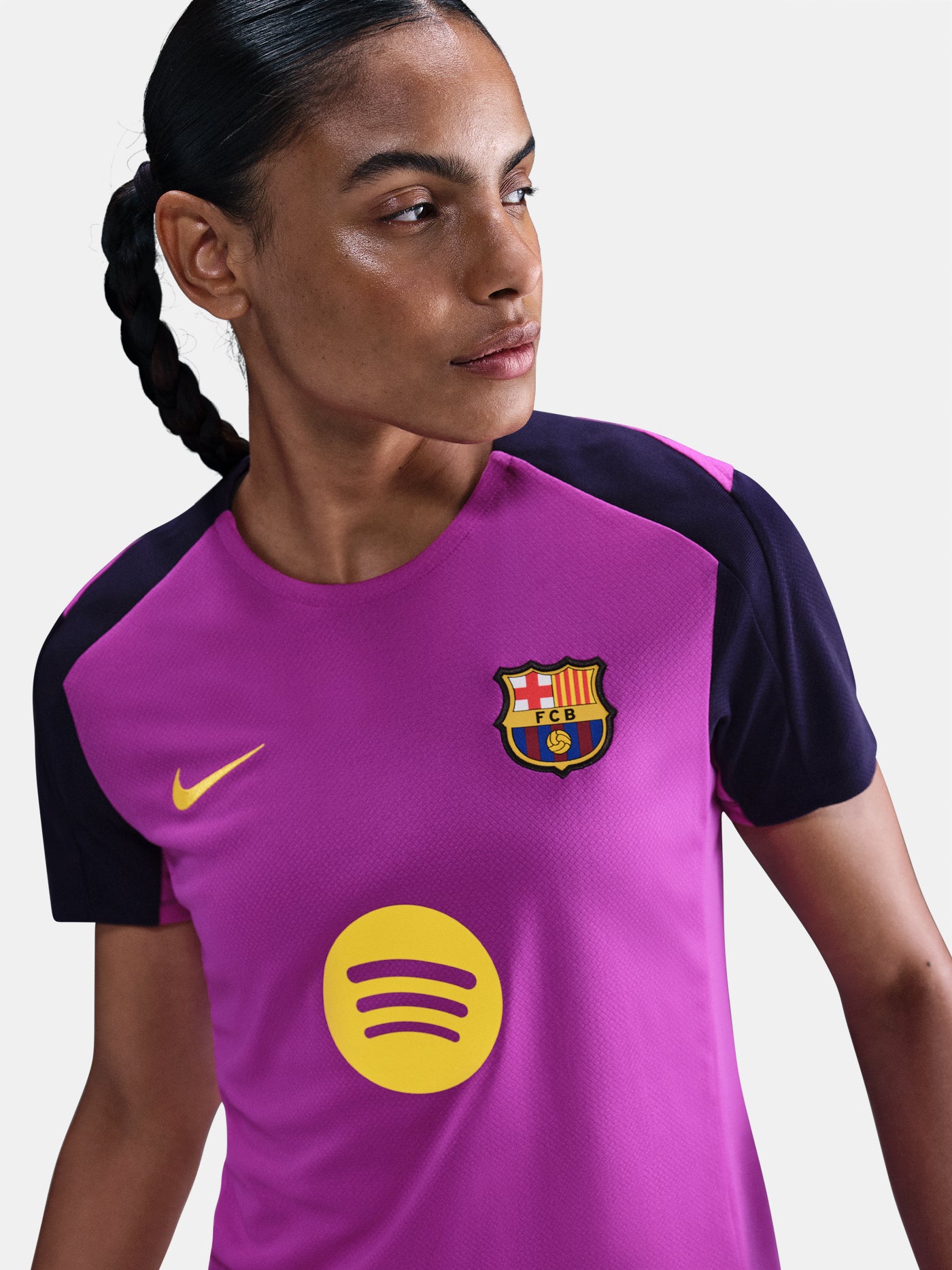 Women's purple FC Barcelona training jersey with navy sleeves, yellow Nike logo, club crest, and Spotify sponsor on the front.