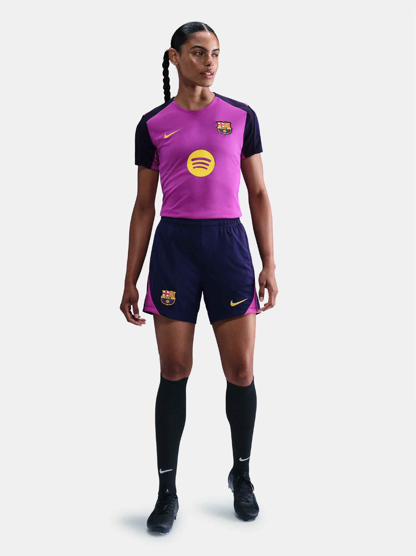 Women's purple FC Barcelona training jersey with navy sleeves, yellow Nike logo, club crest, and Spotify sponsor on the front.