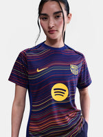 Women's FC Barcelona pre-match jersey with multicolor wave pattern, yellow Nike logo, club crest, and Spotify sponsor on the front.