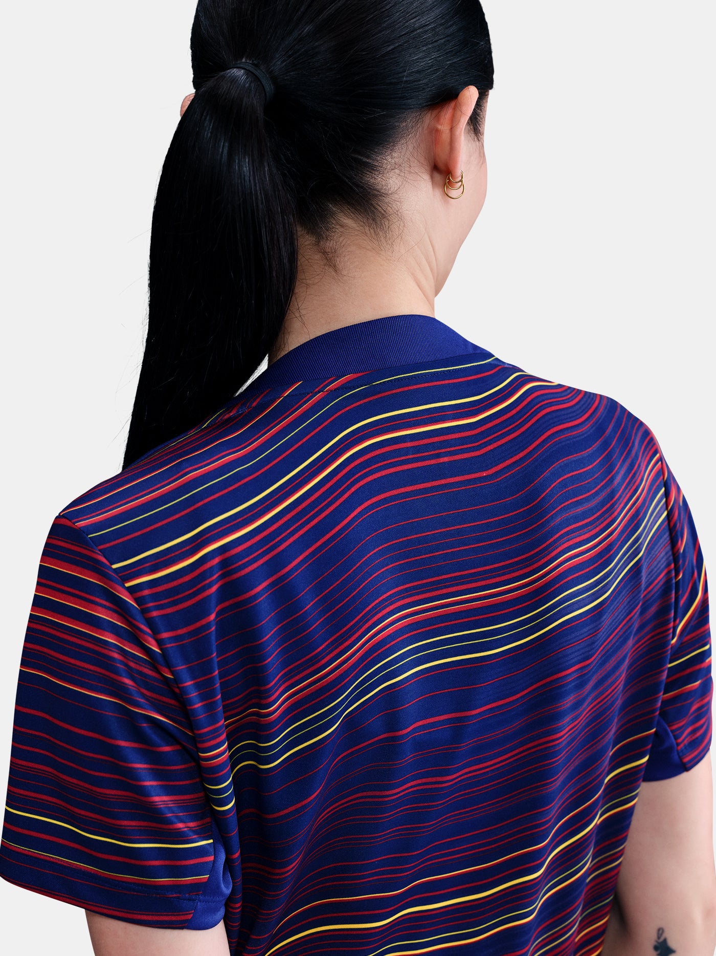 Women's FC Barcelona pre-match jersey with multicolor wave pattern, yellow Nike logo, club crest, and Spotify sponsor on the front.