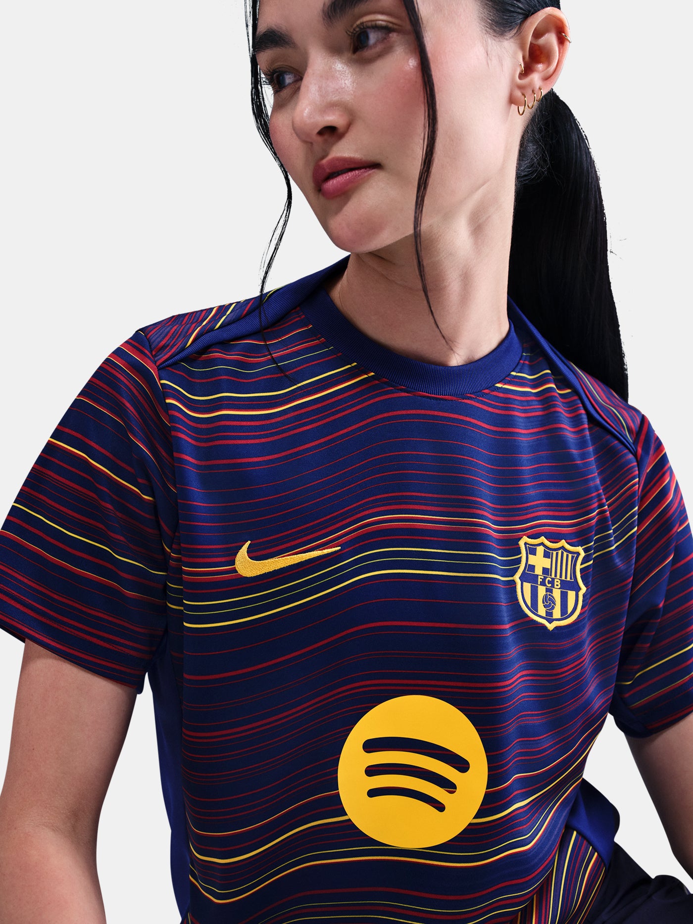 Women's FC Barcelona pre-match jersey with multicolor wave pattern, yellow Nike logo, club crest, and Spotify sponsor on the front.
