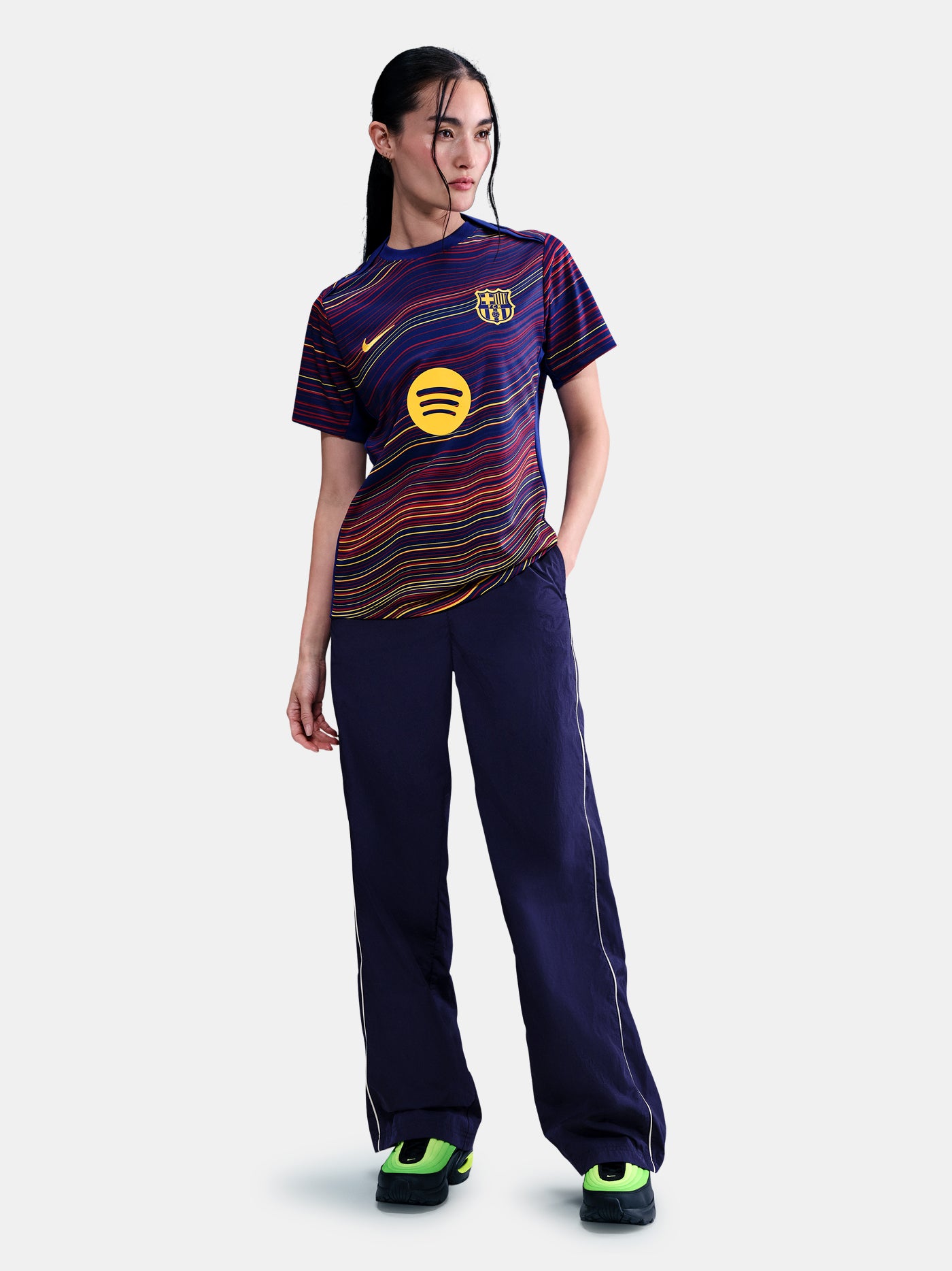 Women's FC Barcelona pre-match jersey with multicolor wave pattern, yellow Nike logo, club crest, and Spotify sponsor on the front.