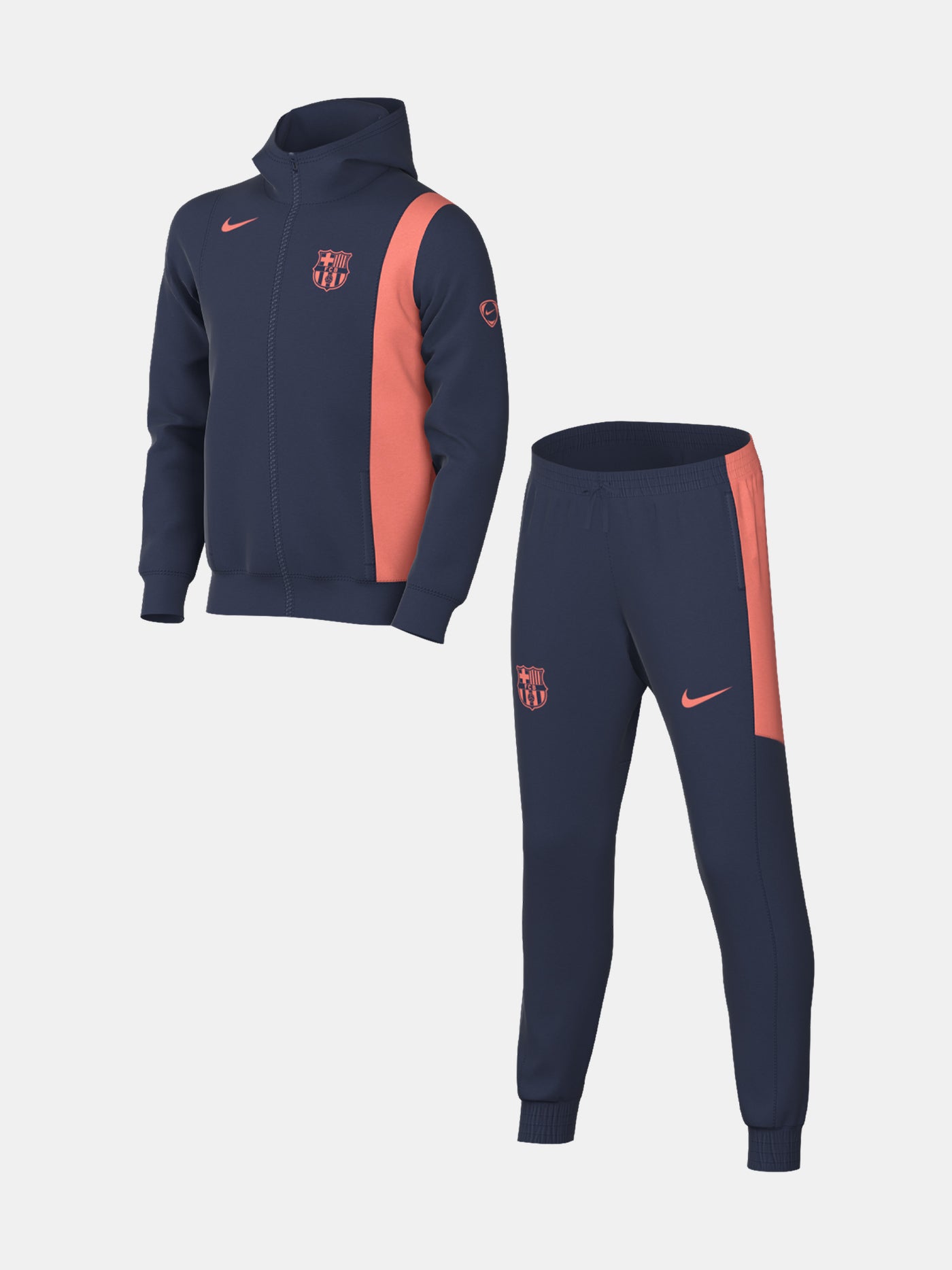 Kid wearing a navy blue FC Barcelona Nike tracksuit with coral details, featuring the club crest and Nike swoosh on the jacket.