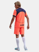 FC Barcelona third kit football shorts in orange with navy blue Nike logo and club crest