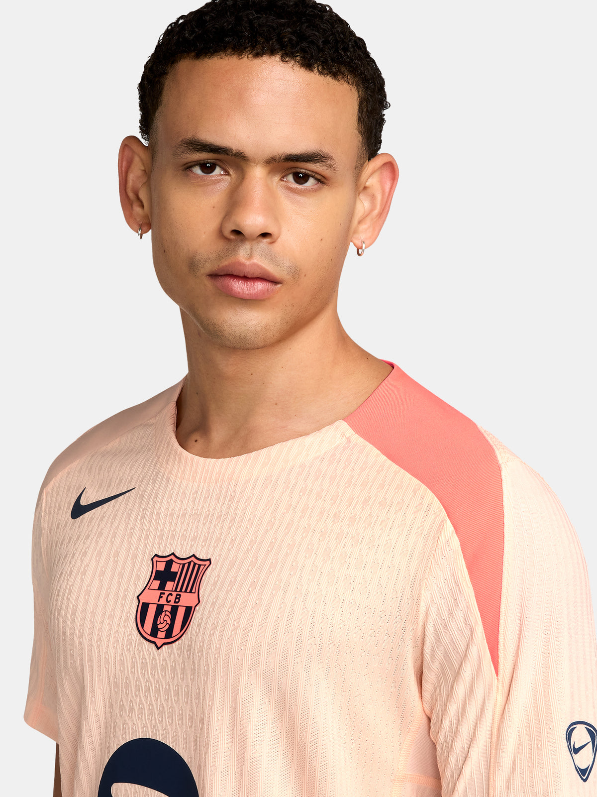 FC Barcelona light pink training jersey with navy Nike logo, Spotify sponsor, and club crest on the chest.