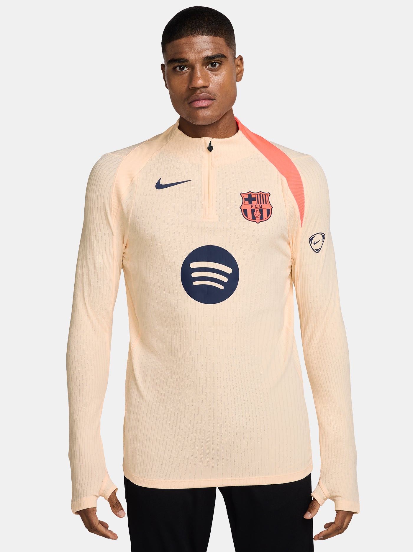 FC Barcelona long-sleeve peach training top with navy Nike logo, club crest, Spotify sponsor, and coral shoulder detail