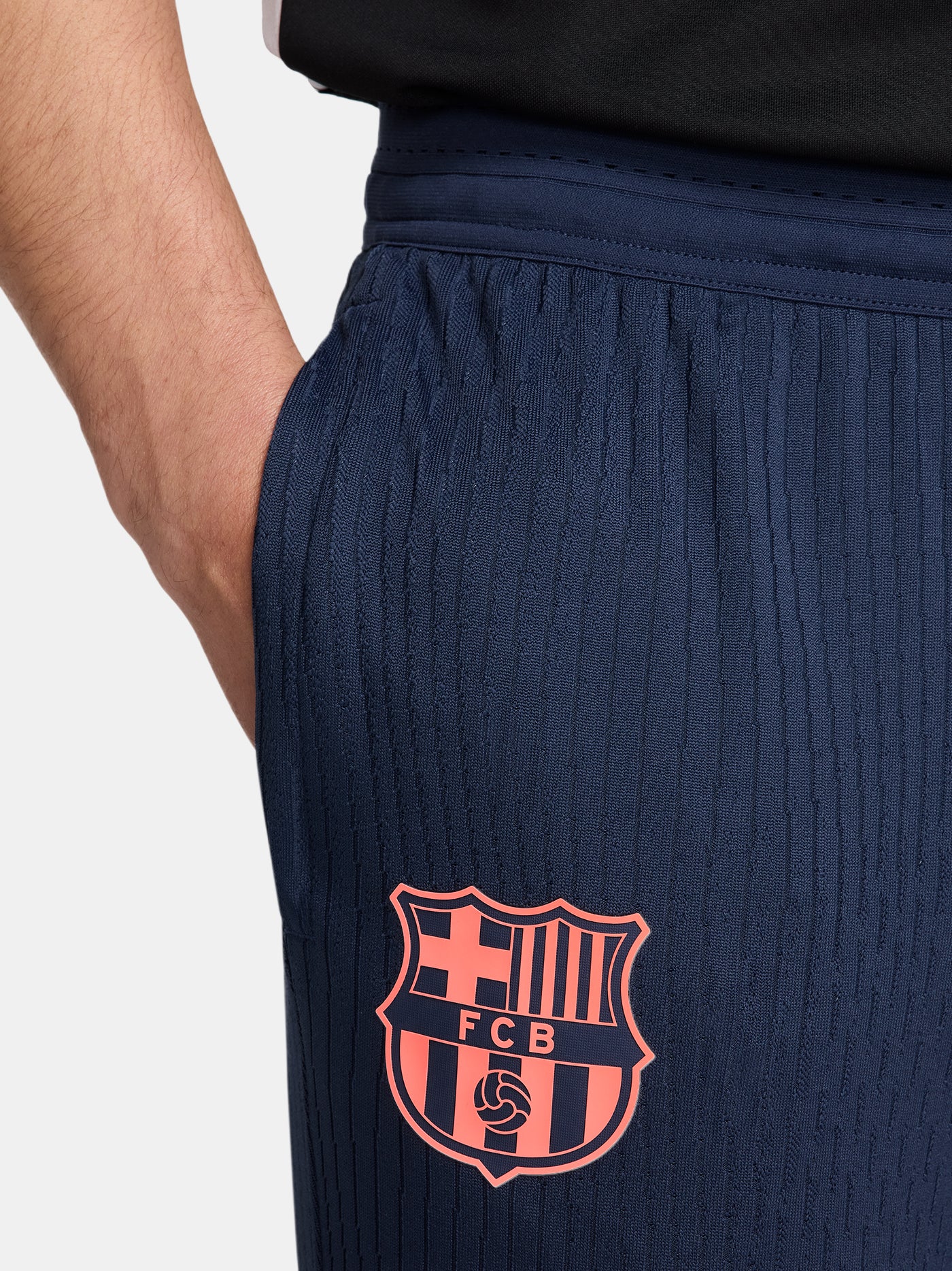 FC Barcelona navy blue training pants with slim fit, featuring the club crest and Nike logo in coral on the front