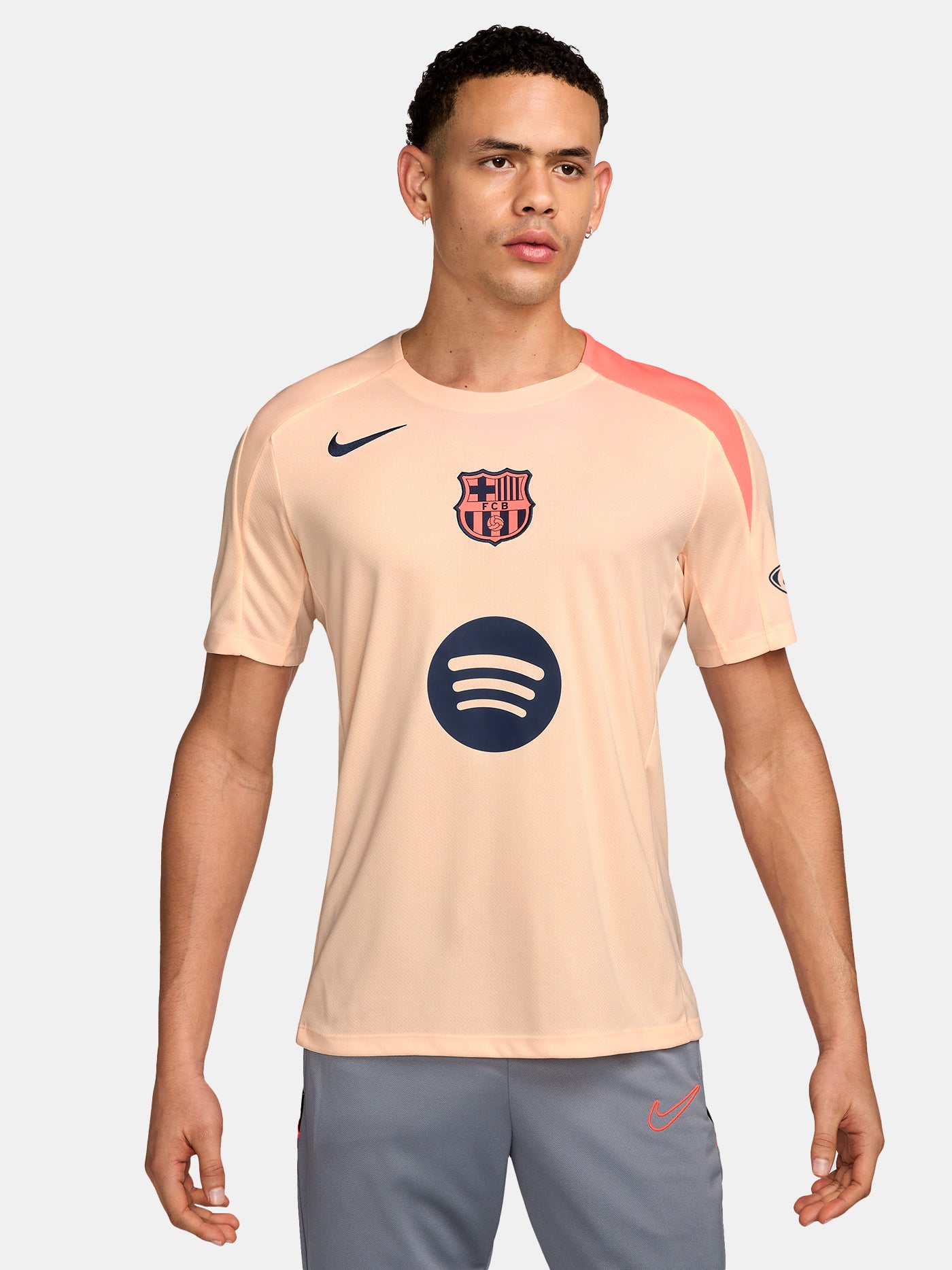 FC Barcelona light pink training jersey with navy Nike logo, Spotify sponsor, and club crest on the chest.