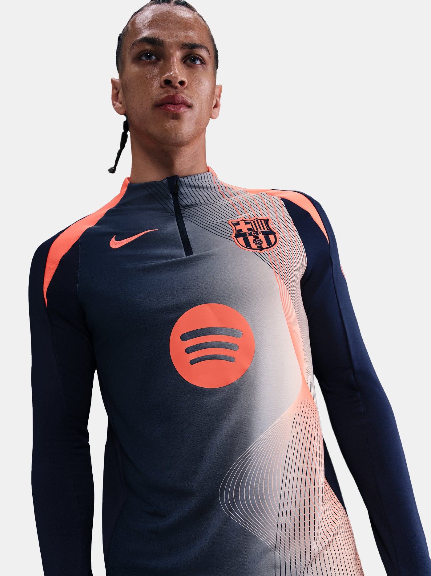 FC Barcelona navy long-sleeve training top with coral Nike logo, Spotify sponsor, and modern coral and white geometric pattern across the chest and shoulders.