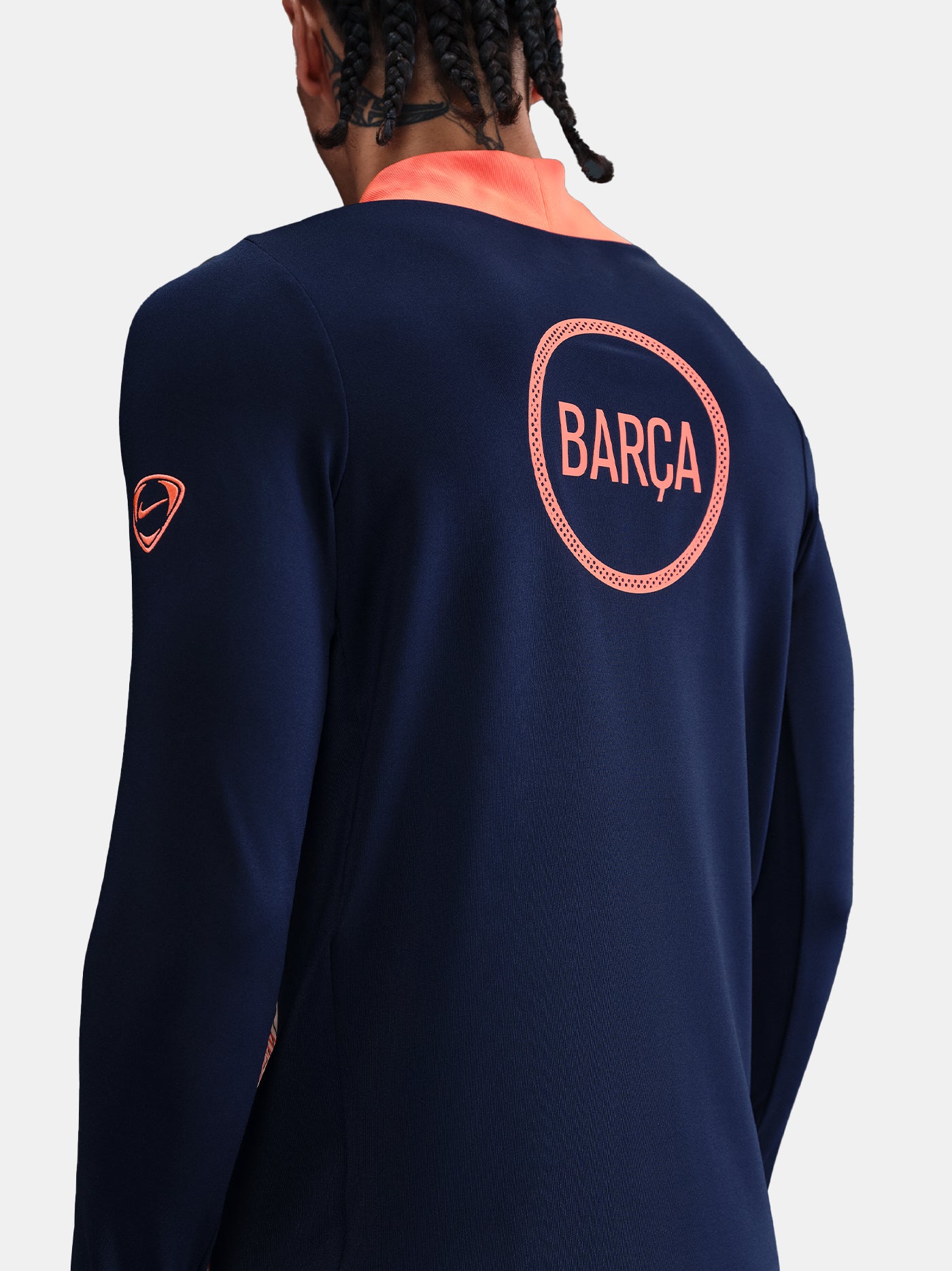 FC Barcelona navy long-sleeve training top with coral Nike logo, Spotify sponsor, and modern coral and white geometric pattern across the chest and shoulders.