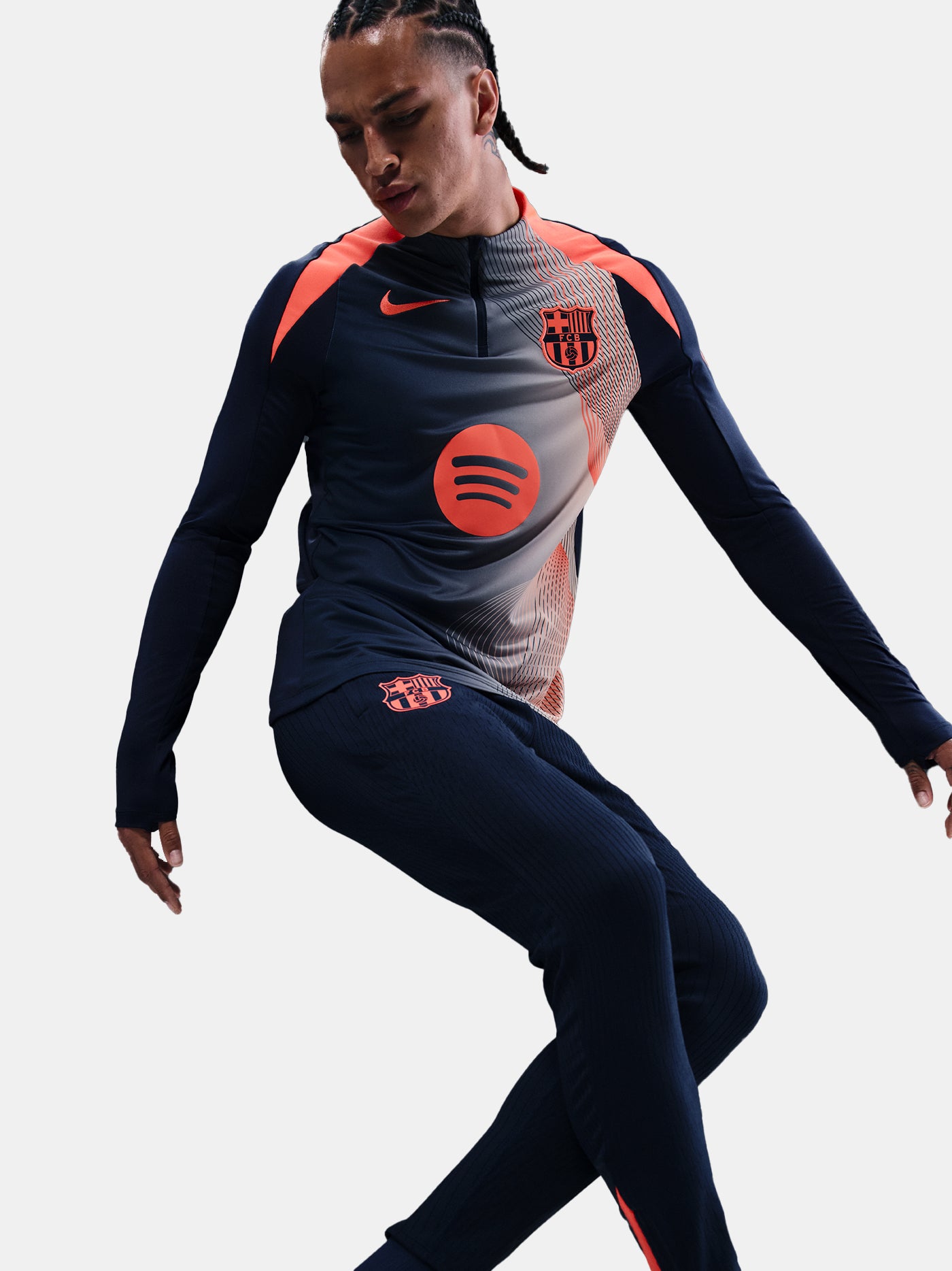 FC Barcelona navy long-sleeve training top with coral Nike logo, Spotify sponsor, and modern coral and white geometric pattern across the chest and shoulders.
