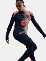 FC Barcelona navy long-sleeve training top with coral Nike logo, Spotify sponsor, and modern coral and white geometric pattern across the chest and shoulders.