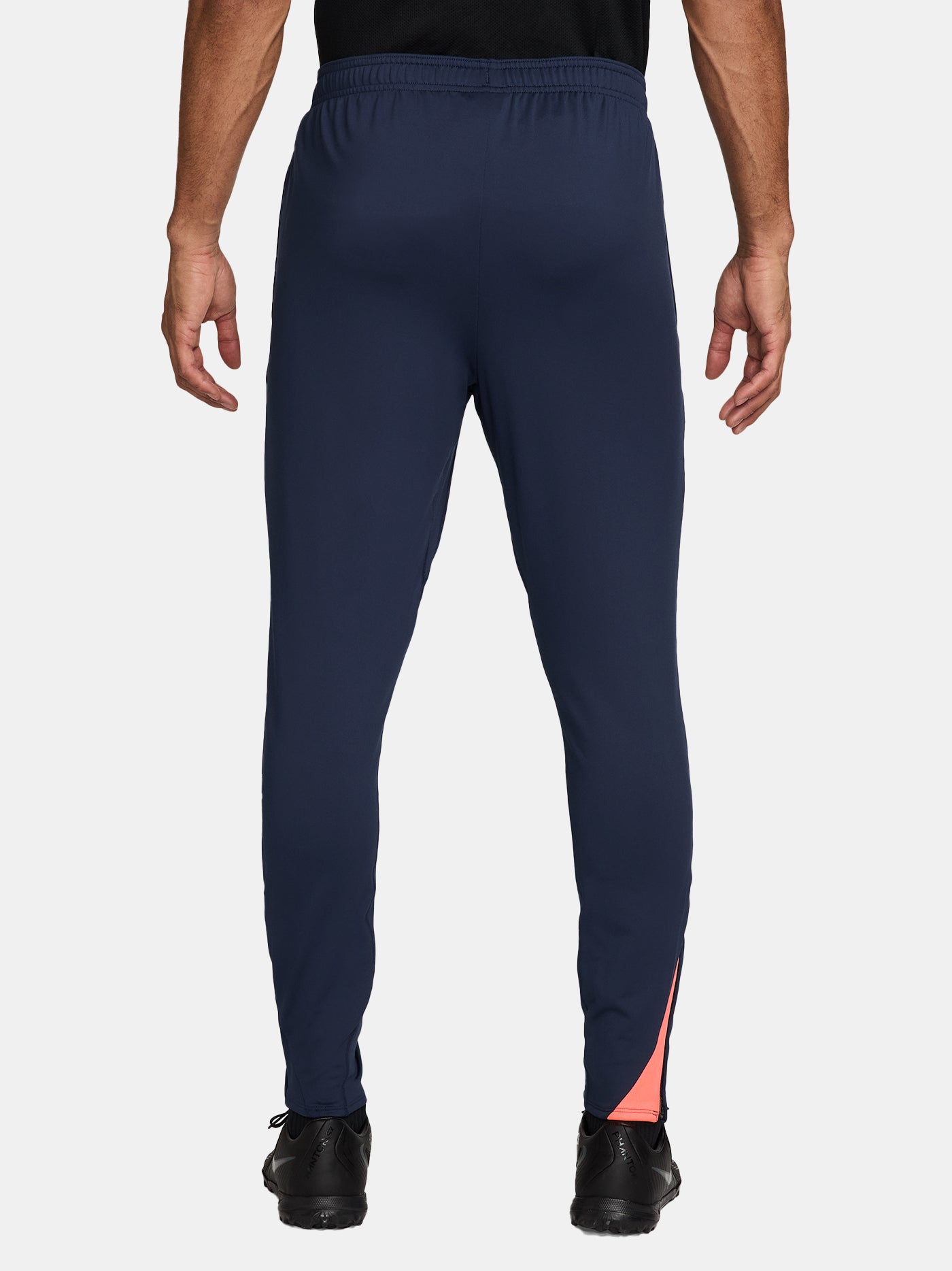 FC Barcelona navy blue training pants with slim fit, featuring the club crest and Nike logo in coral on the front