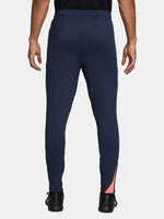 FC Barcelona navy blue training pants with slim fit, featuring the club crest and Nike logo in coral on the front