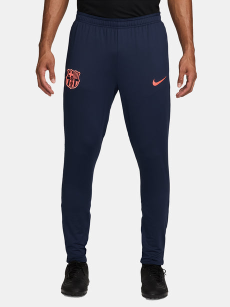 FC Barcelona navy blue training pants with slim fit, featuring the club crest and Nike logo in coral on the front