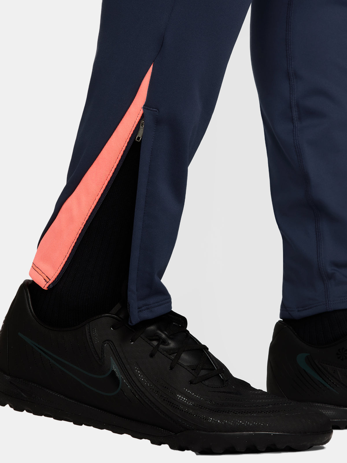 FC Barcelona navy blue training pants with slim fit, featuring the club crest and Nike logo in coral on the front