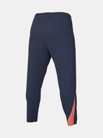 FC Barcelona navy blue training pants with slim fit, featuring the club crest and Nike logo in coral on the front