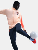 FC Barcelona Nike jacket with coral sleeve detail, paired with navy jogger pants featuring the club crest and Nike swoosh