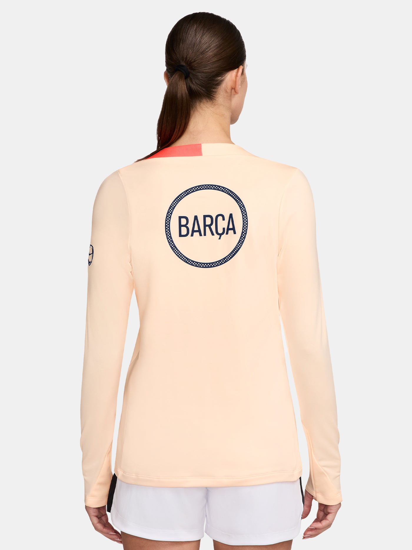 FC Barcelona long-sleeve peach training top with navy Nike logo, club crest, Spotify sponsor, and coral shoulder detail