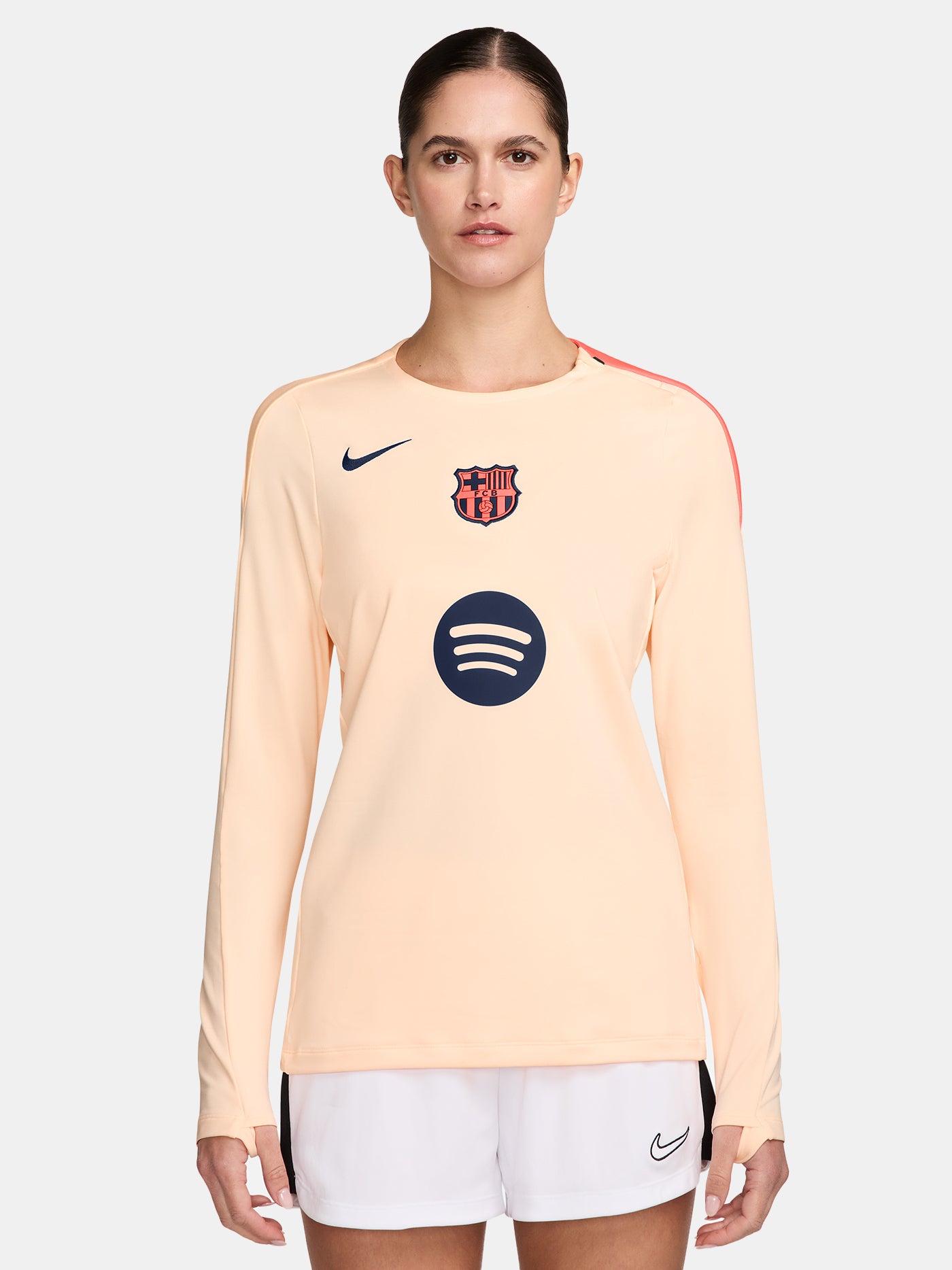 FC Barcelona long-sleeve peach training top with navy Nike logo, club crest, Spotify sponsor, and coral shoulder detail