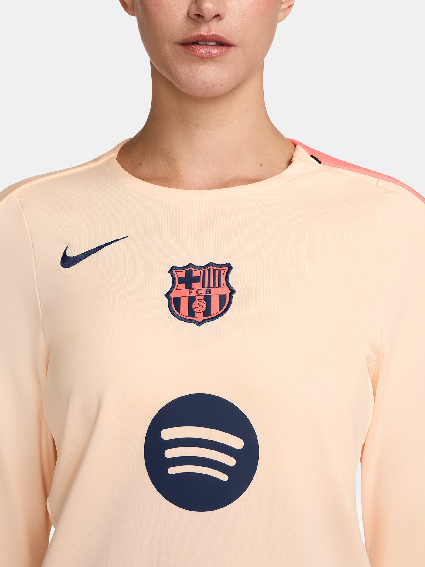 FC Barcelona long-sleeve peach training top with navy Nike logo, club crest, Spotify sponsor, and coral shoulder detail