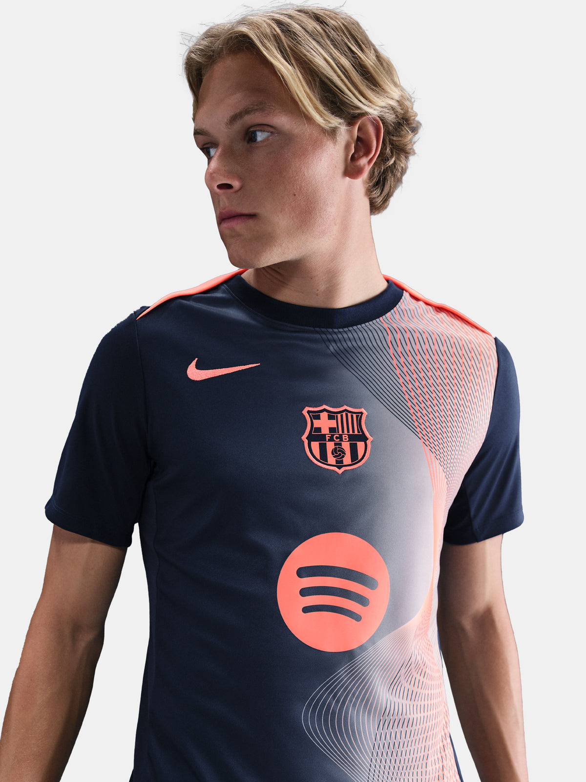 FC Barcelona navy training shirt with coral Nike logo, Spotify sponsor, and geometric coral and white pattern design on the shoulder and chest