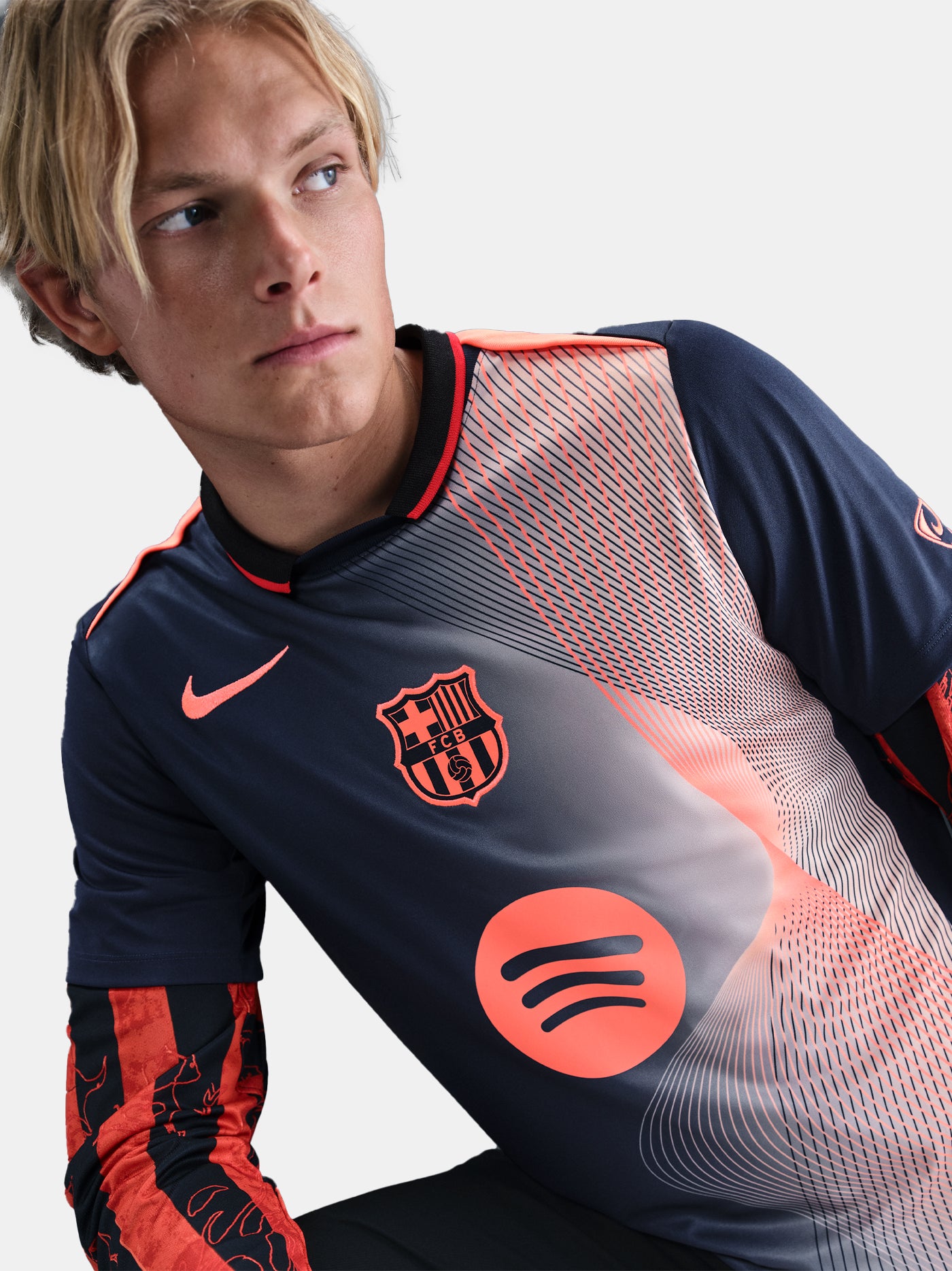 FC Barcelona navy training shirt with coral Nike logo, Spotify sponsor, and geometric coral and white pattern design on the shoulder and chest