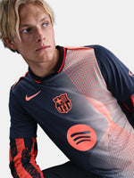 FC Barcelona navy training shirt with coral Nike logo, Spotify sponsor, and geometric coral and white pattern design on the shoulder and chest