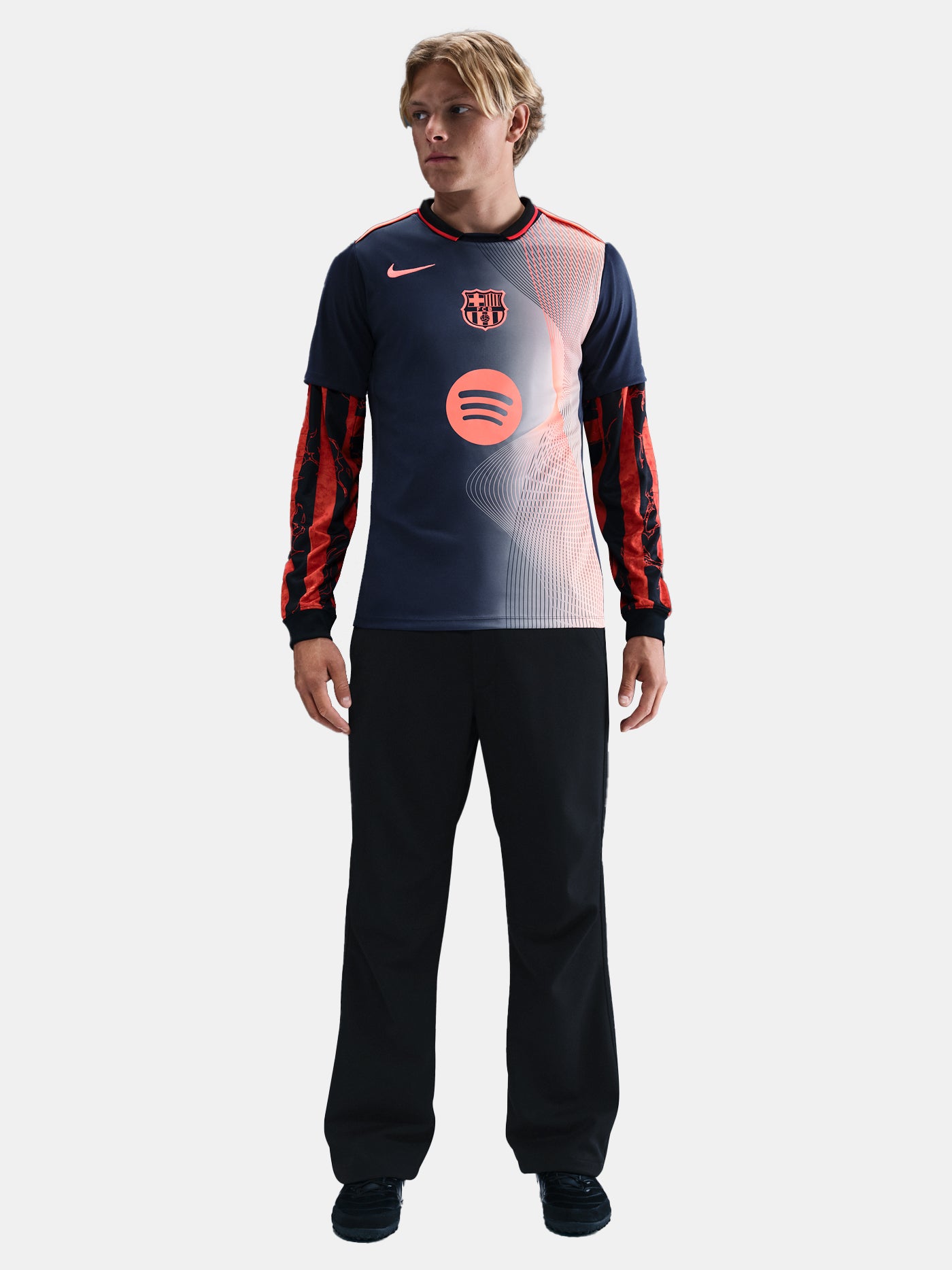 FC Barcelona navy training shirt with coral Nike logo, Spotify sponsor, and geometric coral and white pattern design on the shoulder and chest