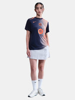 FC Barcelona navy training shirt with coral Nike logo, Spotify sponsor, and geometric coral and white pattern design on the shoulder and chest