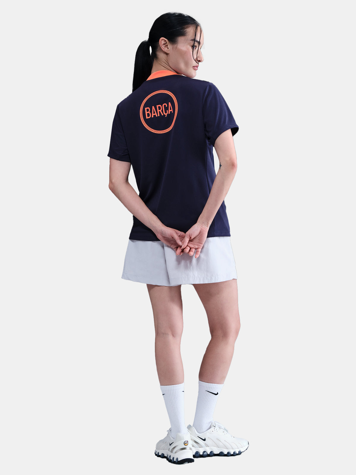 FC Barcelona navy training shirt with coral Nike logo, Spotify sponsor, and geometric coral and white pattern design on the shoulder and chest