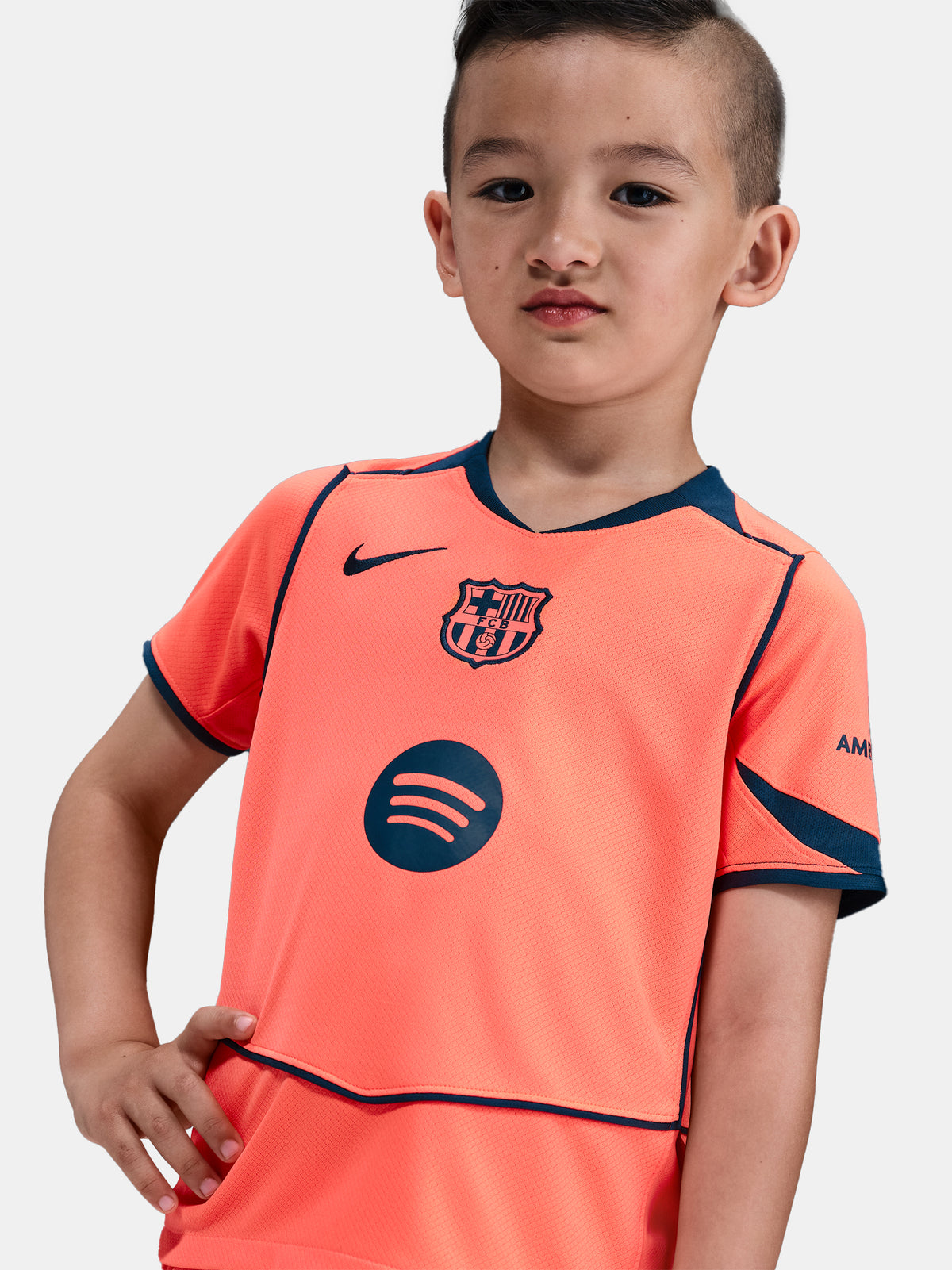 FC Barcelona 2025/26 third kit for kids in orange with navy blue details, including shirt, shorts, and socks.
