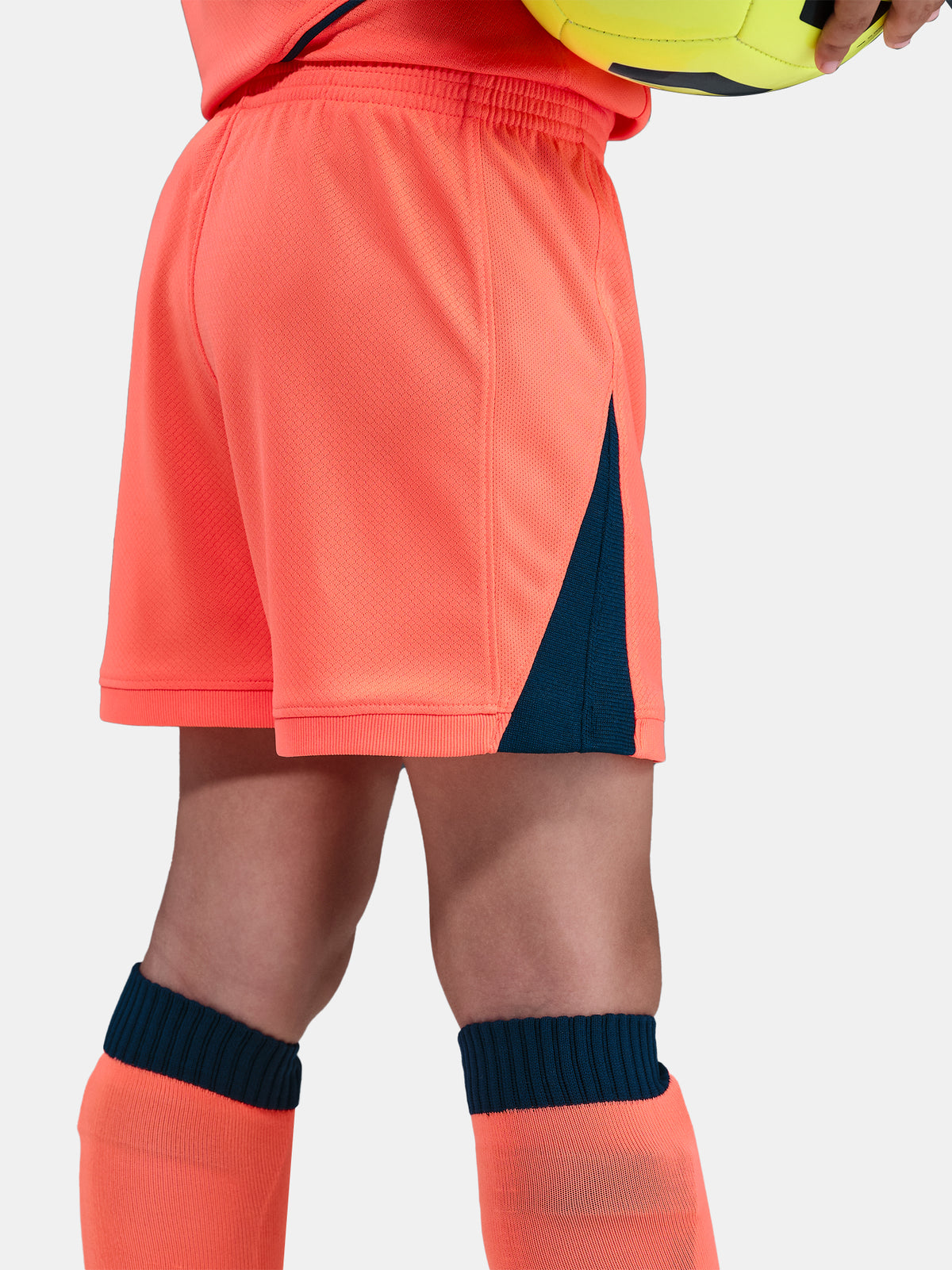 FC Barcelona 2025/26 third kit for kids in orange with navy blue details, including shirt, shorts, and socks.