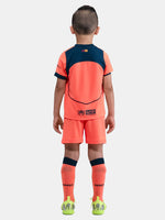 FC Barcelona 2025/26 third kit for kids in orange with navy blue details, including shirt, shorts, and socks.