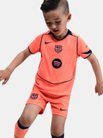 FC Barcelona 2025/26 third kit for kids in orange with navy blue details, including shirt, shorts, and socks.