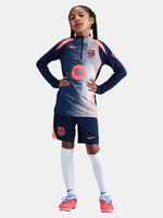 FC Barcelona navy training kit consisting of a long-sleeve top with coral Nike logo, Spotify sponsor and geometric design, paired with matching navy shorts featuring coral accents and the club crest.