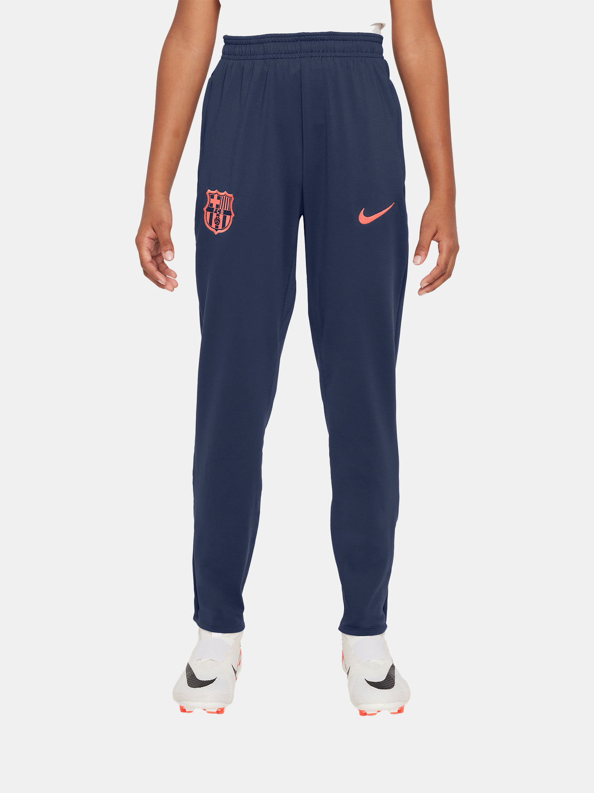 FC Barcelona navy blue training pants with slim fit, featuring the club crest and Nike logo in coral on the front