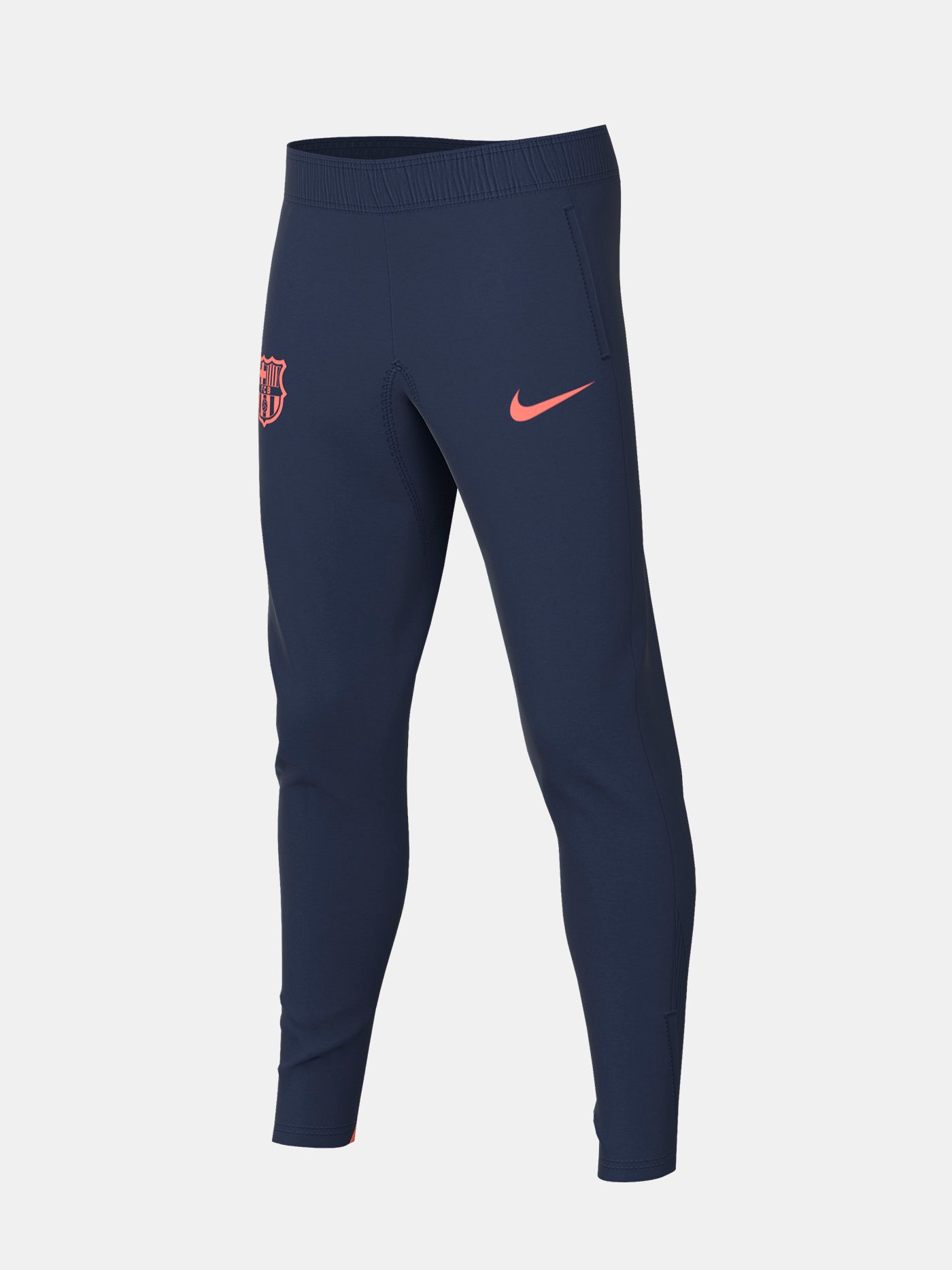 FC Barcelona navy blue training pants with slim fit, featuring the club crest and Nike logo in coral on the front