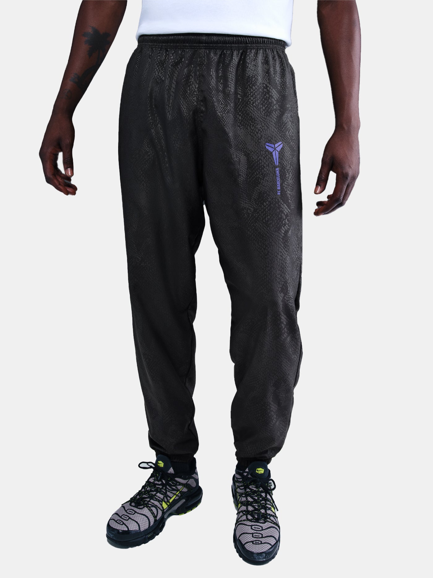 FC Barcelona black training pants with subtle textured pattern and light purple logo on the right thigh