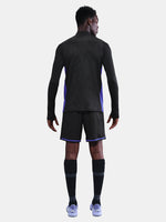 Black FC Barcelona training top with purple details, including the club crest, Nike logo, and Spotify sponsor logo, worn by a person.