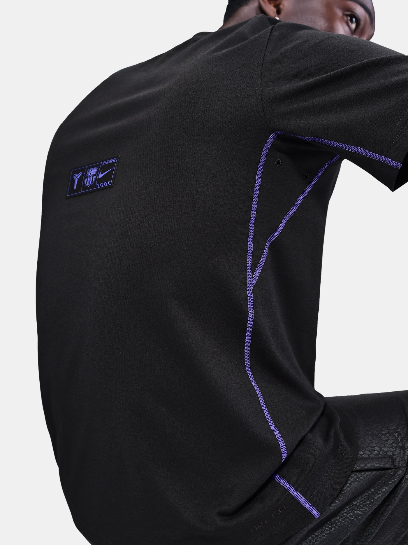 Black FC Barcelona T-shirt with blue Kobe Bryant logo on the chest, paired with black shorts featuring the same emblem.